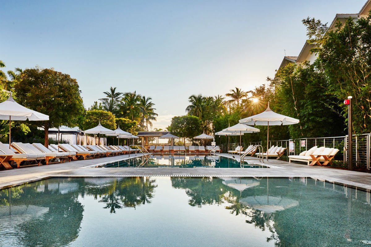 Outdoor pool surrounded by palm trees at the Nautilus hotel in Miami Beach